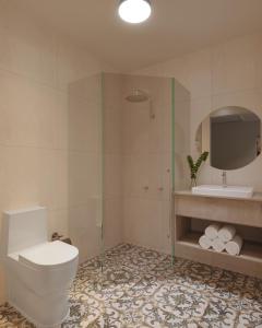 a bathroom with a toilet and a shower and a sink at Nightcap at Esplanade Hotel in Brighton