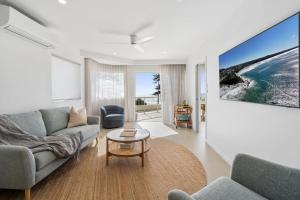 a living room with a couch and a table at 6 Baywatch Apartments in Coolum Beach
