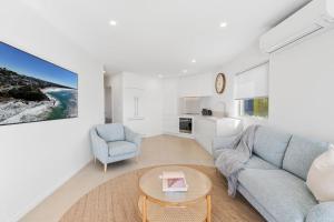 a living room with a couch and a table at 6 Baywatch Apartments in Coolum Beach