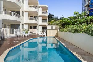 a swimming pool in front of a building at 6 Baywatch Apartments in Coolum Beach