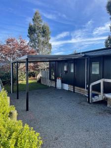 a black shed with awning next to a bench at Playground Fun on Town Doorstep! in Ohakune