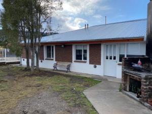 a brick house with a bench in front of it at Lizkar Alojamientos in Esquel