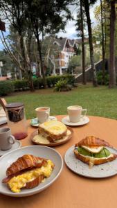 a table with plates of food and cups of coffee at Casa Capivari Boutique in Campos do Jordão