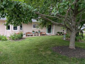 a house with a tree in front of a yard at FIFA Basecamp with 2 Kitchens, 5BR, 4 Baths in Roeland Park