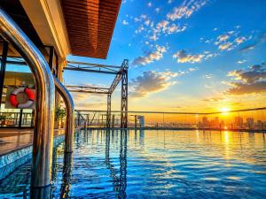 a swimming pool on top of a building with a sunset at Hai Dang Hotel Ha Tinh in Hà Tĩnh