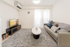 a living room with a couch and a tv at 直达池袋丨东京丨银座无需换乘丨地铁站步行3分钟 丨商店街旁 生活出行方便 in Tokyo