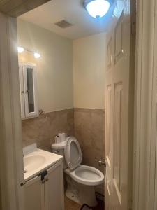 a bathroom with a toilet and a sink and a light at Divine Villa 67 Sherman Ave in Newark