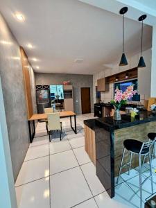 a kitchen and living room with a table and chairs at Casa em Piranhas com piscina in Piranhas