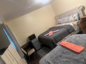 a small bedroom with two beds and a television at Divine Villa 67 Sherman Ave in Newark