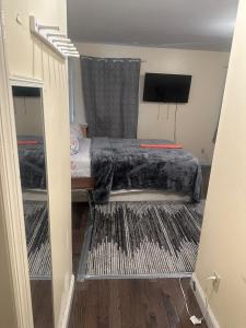 a small bedroom with a bed and a tv at Divine Villa 67 Sherman Ave in Newark