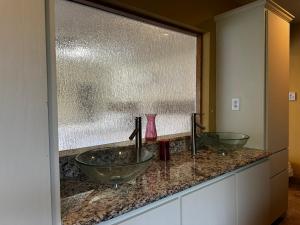 a bathroom counter with two sinks and a window at Madeira Suite in Fort Worth
