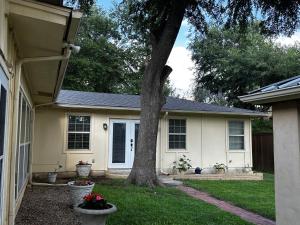a house with a tree in the yard at Madeira Suite in Fort Worth