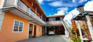 an alley between two buildings with a car parked at SkyBlue Guesthouse by Concavus in Campos do Jordão