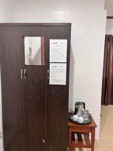 a wooden cabinet with a sign on it next to a table at Kyleville Resort by Hiverooms in Dalaguete