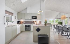 a kitchen and dining room with white cabinets and chairs at Pet Friendly Home In Faaborg With Sauna in Faaborg +5 photos