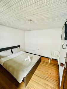 a bedroom with a bed and a chair in it at Hotel Colonial El Gran Fénix in Tunja +15 photos