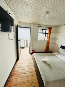 a bedroom with a large bed and a window at Hotel Colonial El Gran Fénix in Tunja