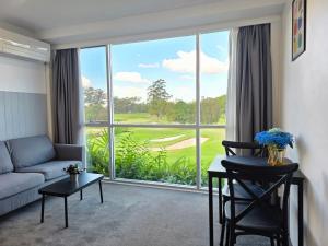 a living room with a couch and a large window at The Select Inn Ryde in Sydney