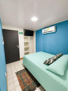 a bedroom with a bed with a blue wall at inn house almendros in San Andrés