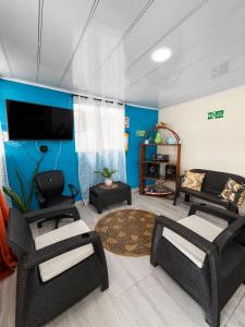 a living room with a couch and chairs and a tv at inn house almendros in San Andrés