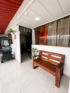 a wooden bench sitting on a porch next to a building at inn house almendros in San Andrés +1 photo