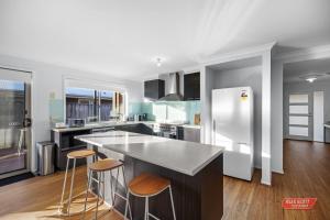 a kitchen with a counter and stools in it at Getaway on Grampian 2 - 8 guests Pets allowed in Cowes