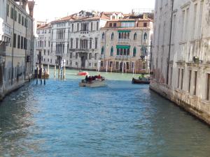 two boats in a canal between two buildings at Apartment Cafoscari in Venice