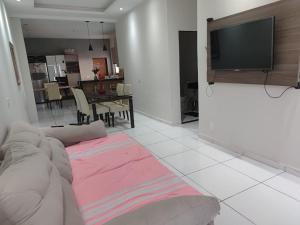a living room with a couch and a tv on a wall at Casa em Piranhas com piscina in Piranhas