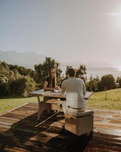 a man and woman sitting at a picnic table at Sleek, Elevated Views, Hidden - KK43103 in Kaikoura