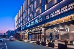 a large building with a sign on the side of it at Crystal Orange Hotel Suzhou Xiangcheng in Suzhou