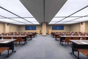 an empty lecture hall with tables and chairs at Crystal Orange Hotel Suzhou Xiangcheng in Suzhou