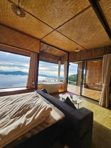 a bedroom with a large bed and a bath tub at Mon Ngo misty haven B2 in Ban Mae Ta Man