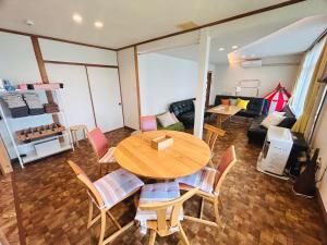 a living room with a wooden table and chairs at Higashikawa home in Higashikawa