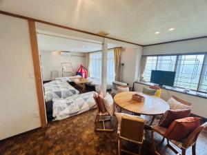 a room with a bed and a table and a bedroom at Higashikawa home in Higashikawa