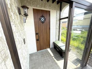 a door with a bench in front of a house at Higashikawa home in Higashikawa