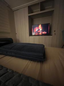 a bedroom with a bed with a tv on the wall at Exclusivo departamento in Valdivia