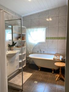 a white bathroom with a tub and a sink at Riverstone Cottage at Murray Bridge in Murray Bridge +14 photos
