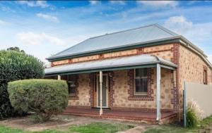 an old brick house with a metal roof at Riverstone Cottage at Murray Bridge in Murray Bridge