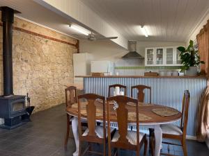a kitchen with a wooden table with chairs and a stove at Riverstone Cottage at Murray Bridge in Murray Bridge