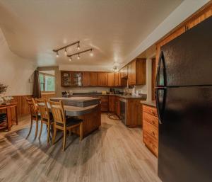 a kitchen with wooden cabinets and a black refrigerator at Gateway to Glacier in Columbia Falls