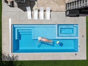 a person swimming in a swimming pool with a ball at Lambeau View Pool Rooftop Entertainment Room in Green Bay