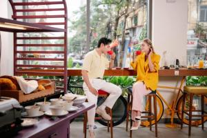 a man and a woman sitting on a chair in a room at Wink Hai Phong Centre, Unscripted by Hyatt - 24 Hours stay in Hai Phong