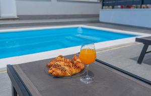 a glass of beer and a plate of bread next to a pool at Gorgeous Home In Primosten in Primošten +25 photos