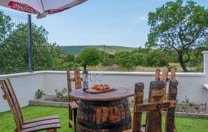 a wooden table with two chairs and a plate of fruit at Gorgeous Home In Primosten in Primošten