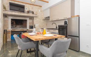 a kitchen with a table with chairs and a refrigerator at Gorgeous Home In Primosten in Primošten