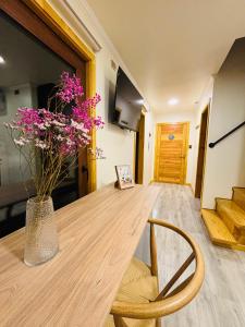 a wooden table with a vase of flowers on it at Hotel Neyün La Junta in La Junta