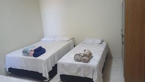 two beds in a room with towels on them at Studio Figueira, Casa in Santarém