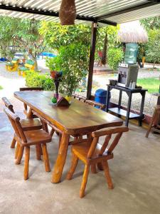 a wooden picnic table and two chairs and a table and chairs at ECORAUDAL posada campestre in San José del Guaviare
