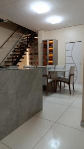 a dining room with a table and a staircase at Hospedagem Caripi in Barcarena
