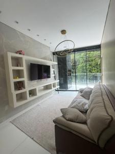 a living room with a couch and a flat screen tv at Hospedagem Caripi in Barcarena